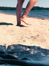 Low section of man standing on beach