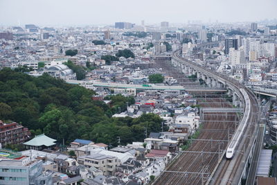 Bullet trains in tokyo through the city with trees