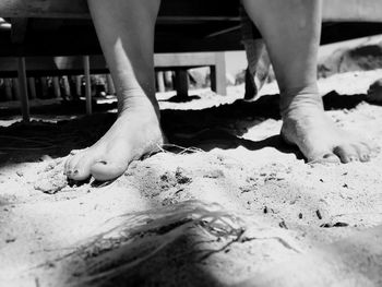 Low section of person standing on sand