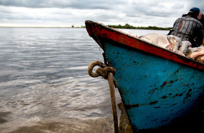 Boat moored at beach against sky