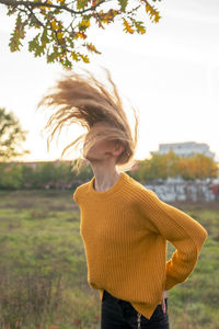 Woman standing by plant against sky