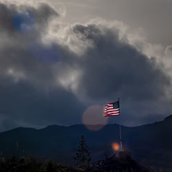 Low angle view of flag against mountain range