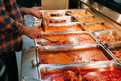 Midsection of man with curry food in a restaurant