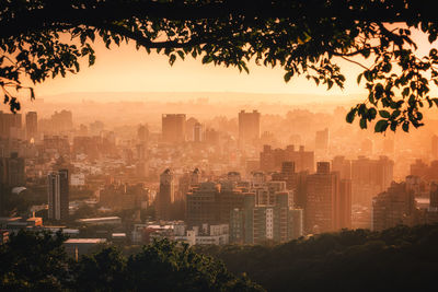 Aerial view of buildings in city at sunset