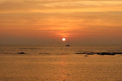 Scenic view of sea against orange sky