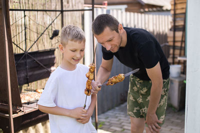 Side view of young man holding plant