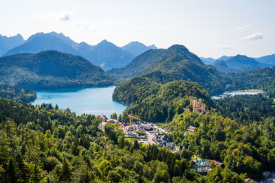 Scenic view of townscape by mountains against sky