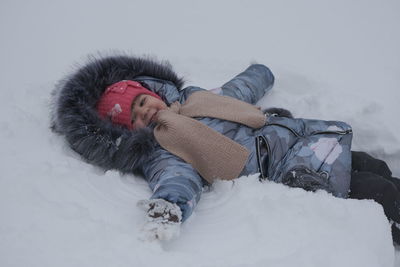 Full length of child lying down on snow