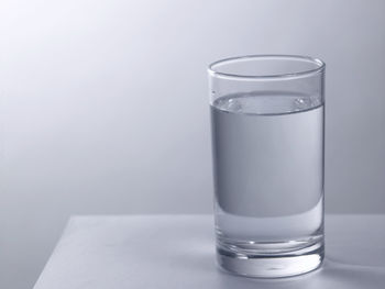 Glass of clear water on the gray background