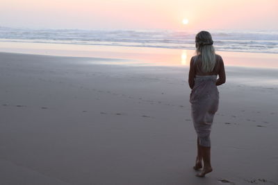 Rear view of woman standing on beach