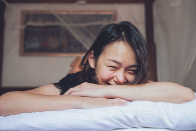 Portrait of woman lying on bed at home