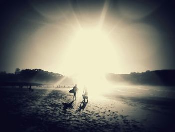 Man on beach against bright sun