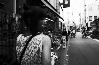 Rear view of woman looking at city street