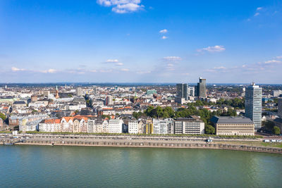 Aerial view of buildings in city against sky