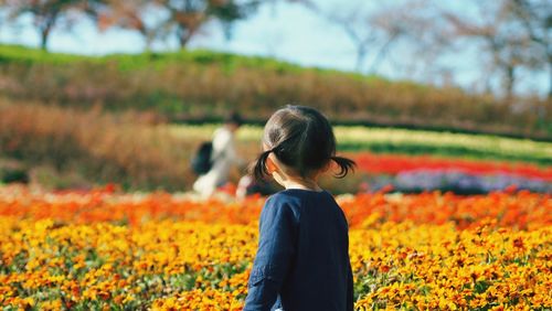Rear view of woman standing on field