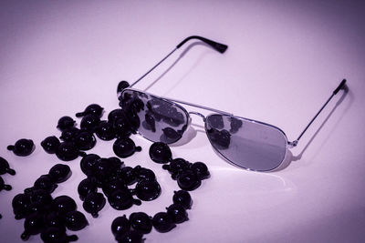 Close-up of berries on glass table against white background