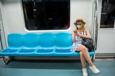 Portrait of a smiling young woman sitting on seat