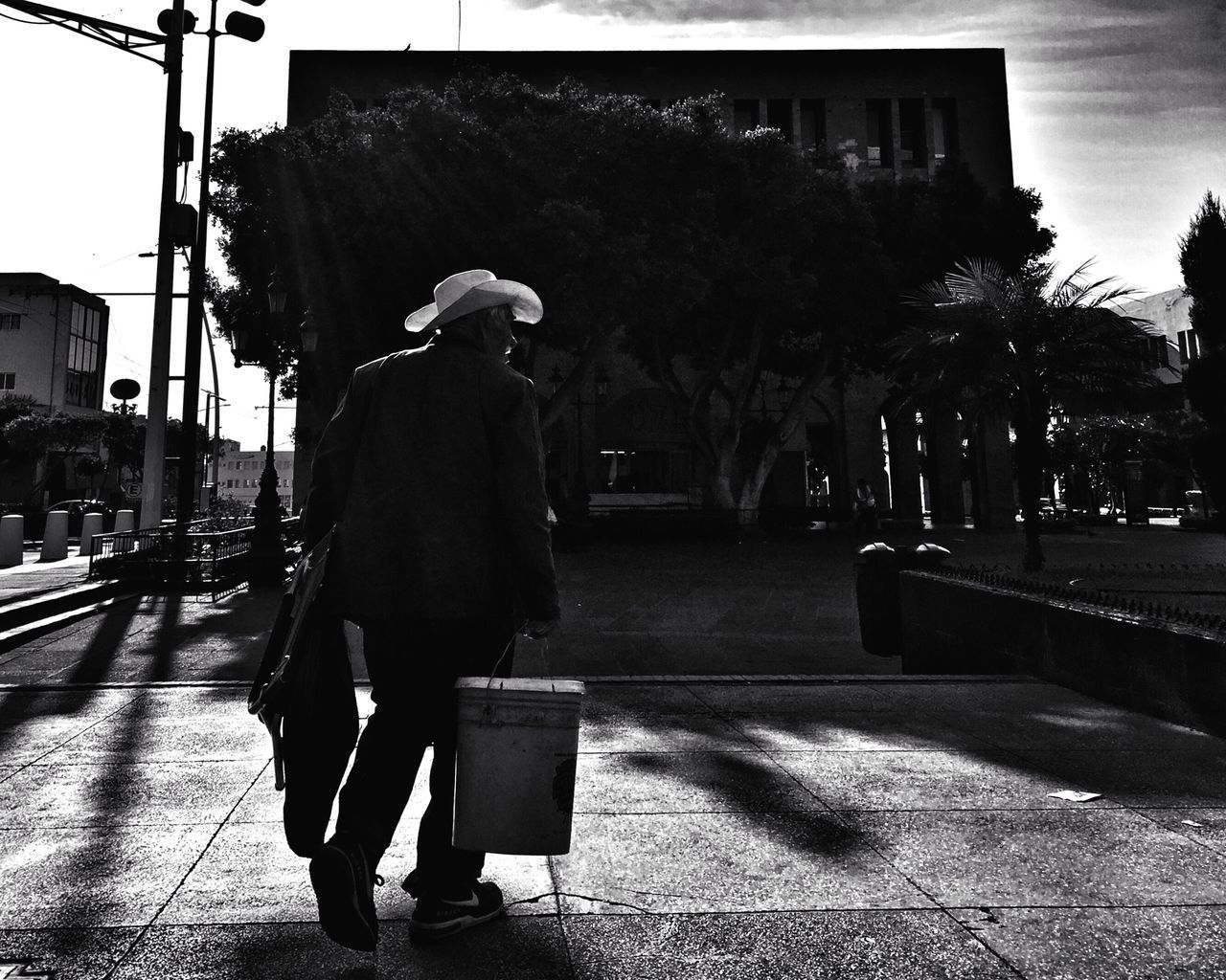 full length, street, city, lifestyles, rear view, walking, building exterior, city life, men, sidewalk, transportation, built structure, leisure activity, architecture, road, casual clothing, person, tree