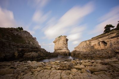 Low angle view of rock formation against sky