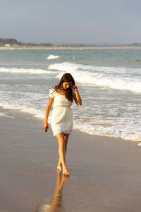 Rear view of woman walking on beach