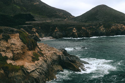 Scenic view of sea and mountains against sky