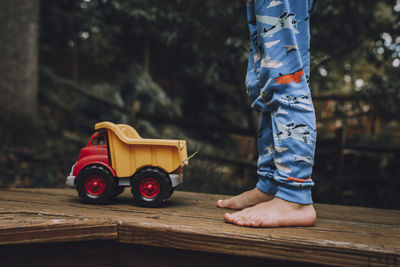 Low section of child hand on wooden car
