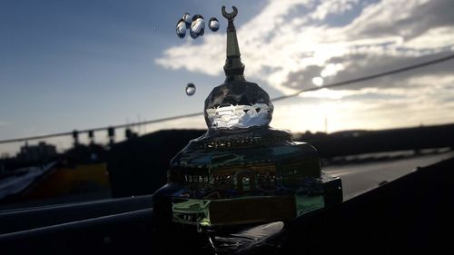 Close-up of coin-operated binoculars against sky at sunset