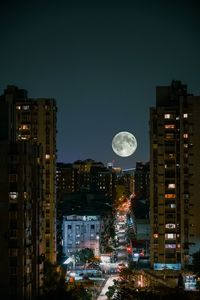 Illuminated buildings against sky at night