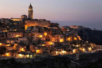 Illuminated cityscape against sky at night