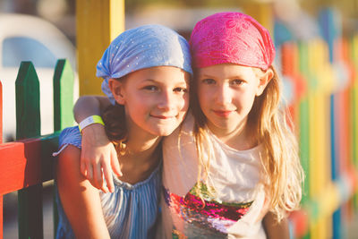 Portrait of sisters standing at railing