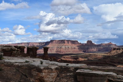 Rock formations on landscape against cloudy sky