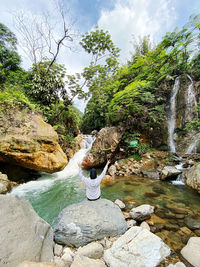 Full frame shot of waterfall on rock against sky