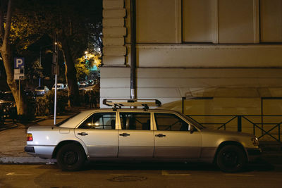 Car parked on street against building at night