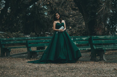 Smiling woman standing by benches on field