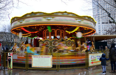 Woman in amusement park against clear sky