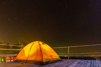 Illuminated tent against sky at night