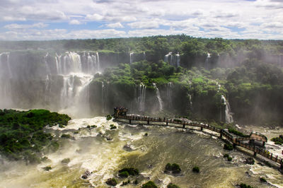 View of waterfall against cloudy sky