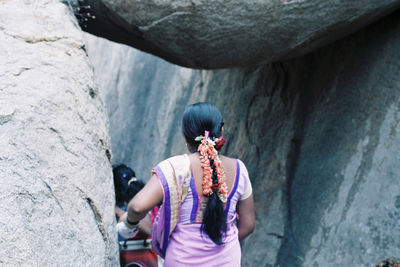 Rear view of woman standing on rock
