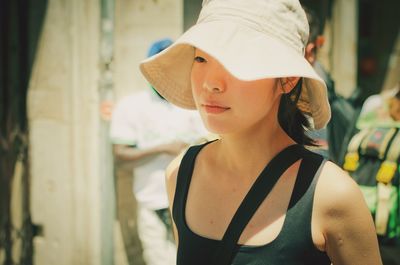 Close-up of young woman wearing hat on sunny day