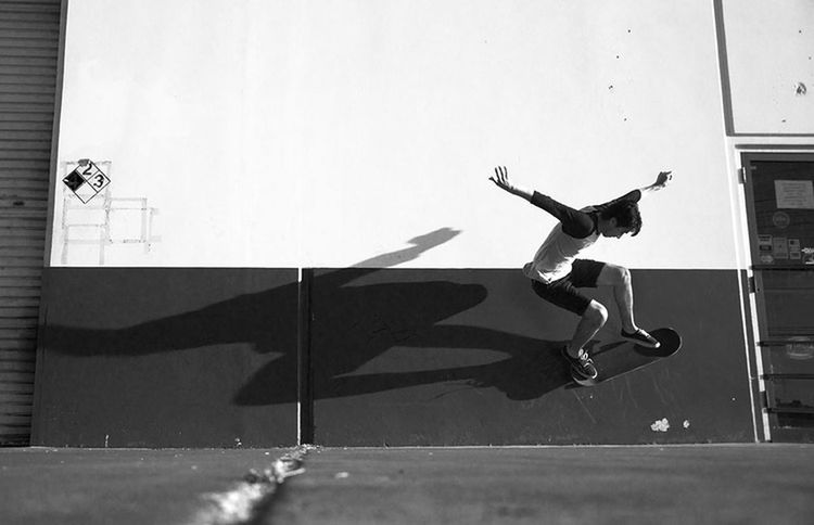 built structure, full length, wall - building feature, shadow, architecture, sunlight, low angle view, day, building exterior, mid-air, indoors, skill, side view, motion, skateboard, sport, street