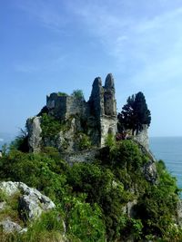 Low angle view of castle on rock against sky