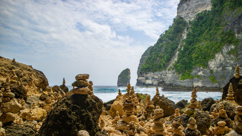 Rock formations by sea against sky