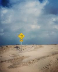 Yellow flag on beach against sky