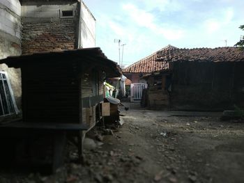 Old building by street against sky