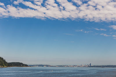 Scenic view of sea by buildings against sky