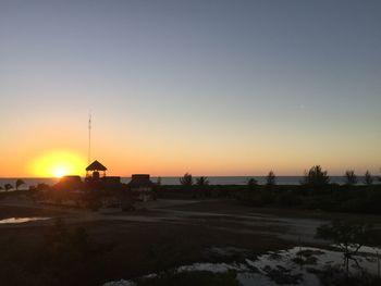 Scenic view of silhouette buildings against clear sky during sunset