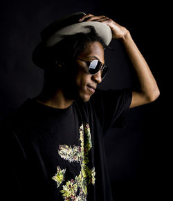 Smiling man wearing hat over black background