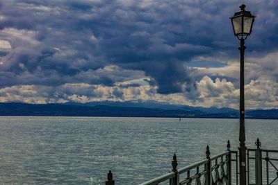 Street light by sea against sky