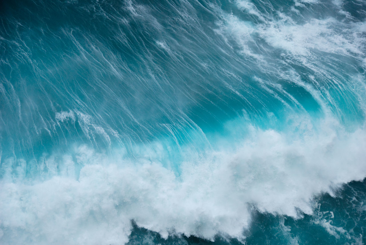 HIGH ANGLE VIEW OF WAVE SPLASHING IN SEA