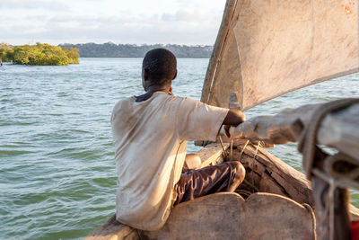 Rear view of man on boat sailing in river